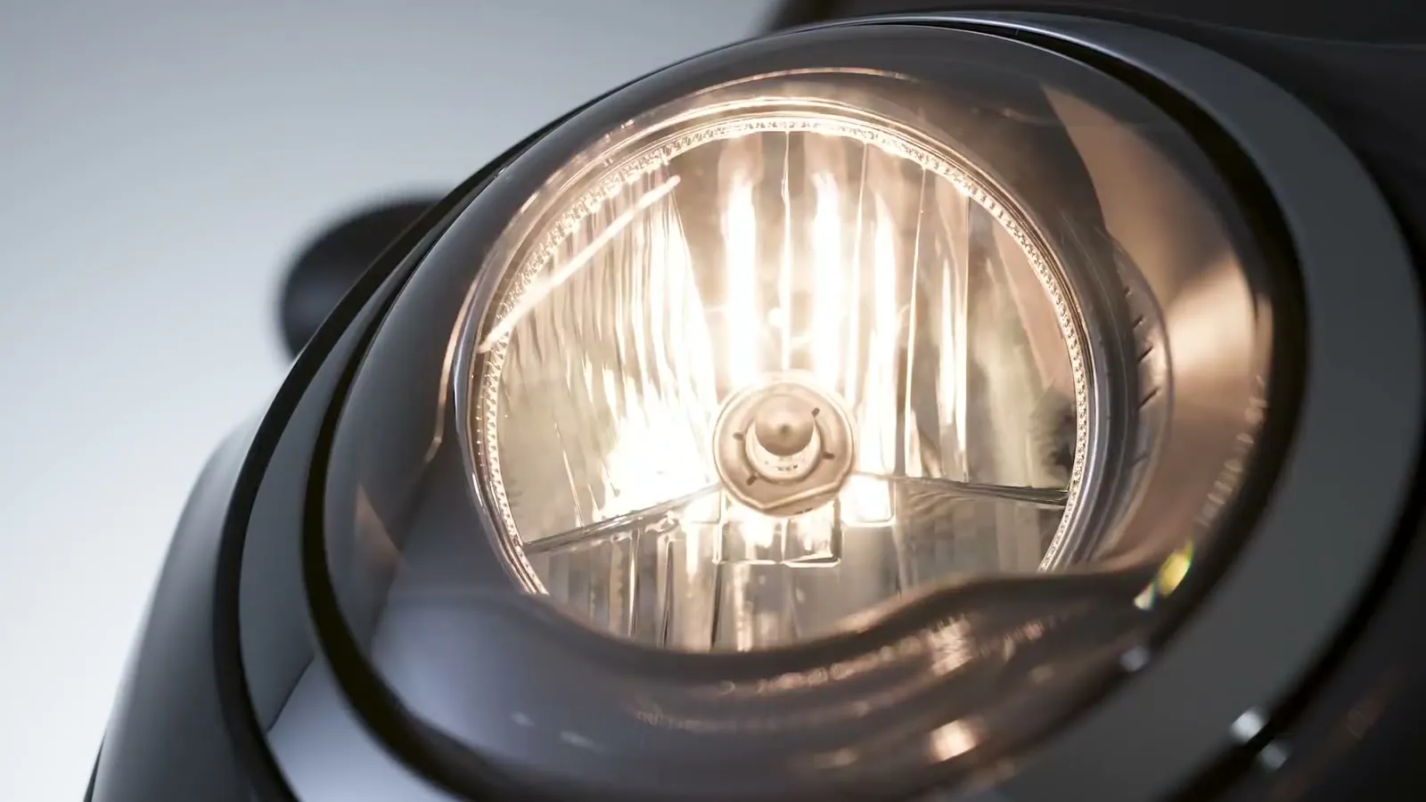 De koplamp uitgelicht tegen de donkere carrosserie