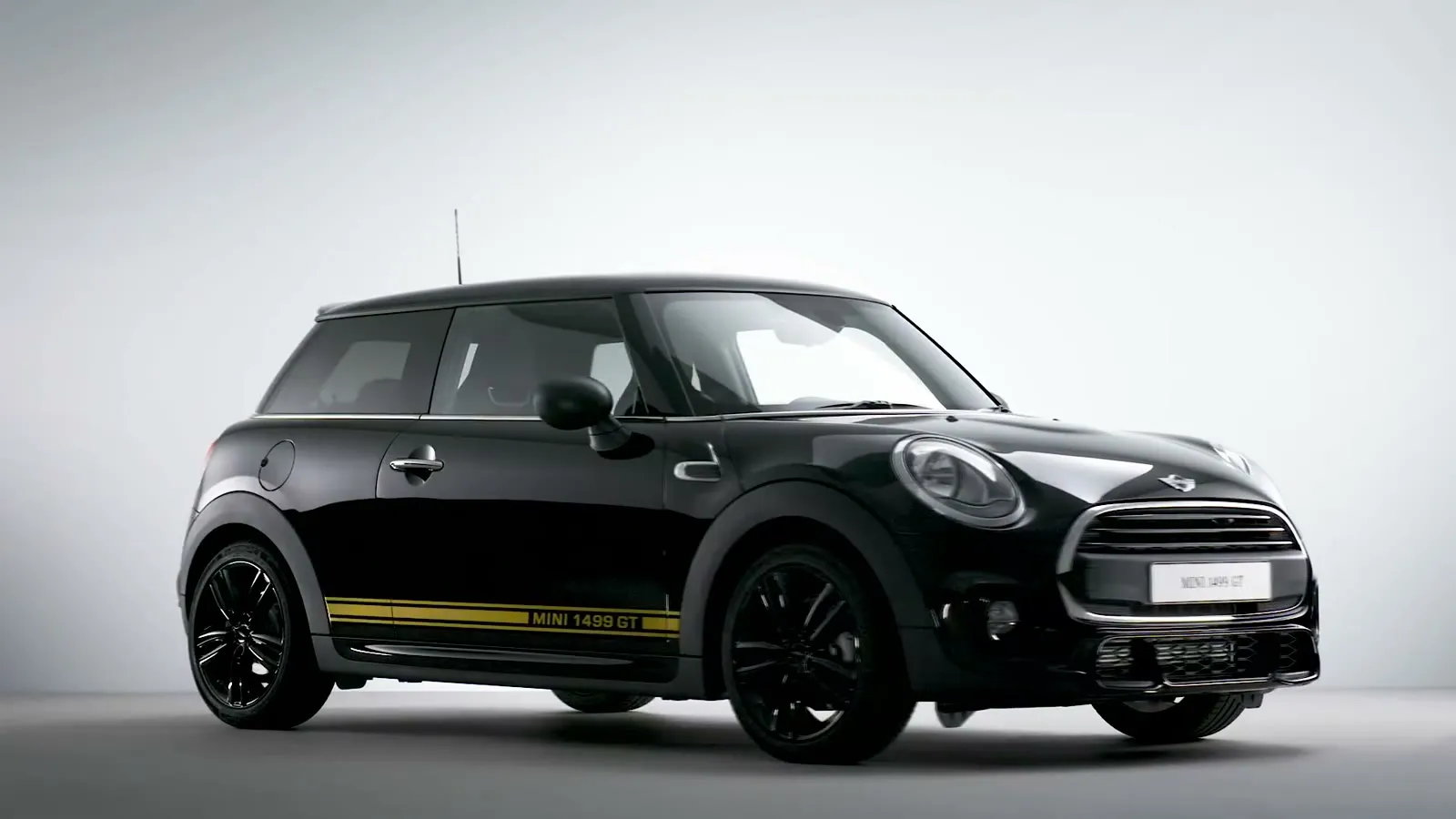 De MINI 1499 GT Limited Edition, zwart met een gele streep, uitgelicht op wit