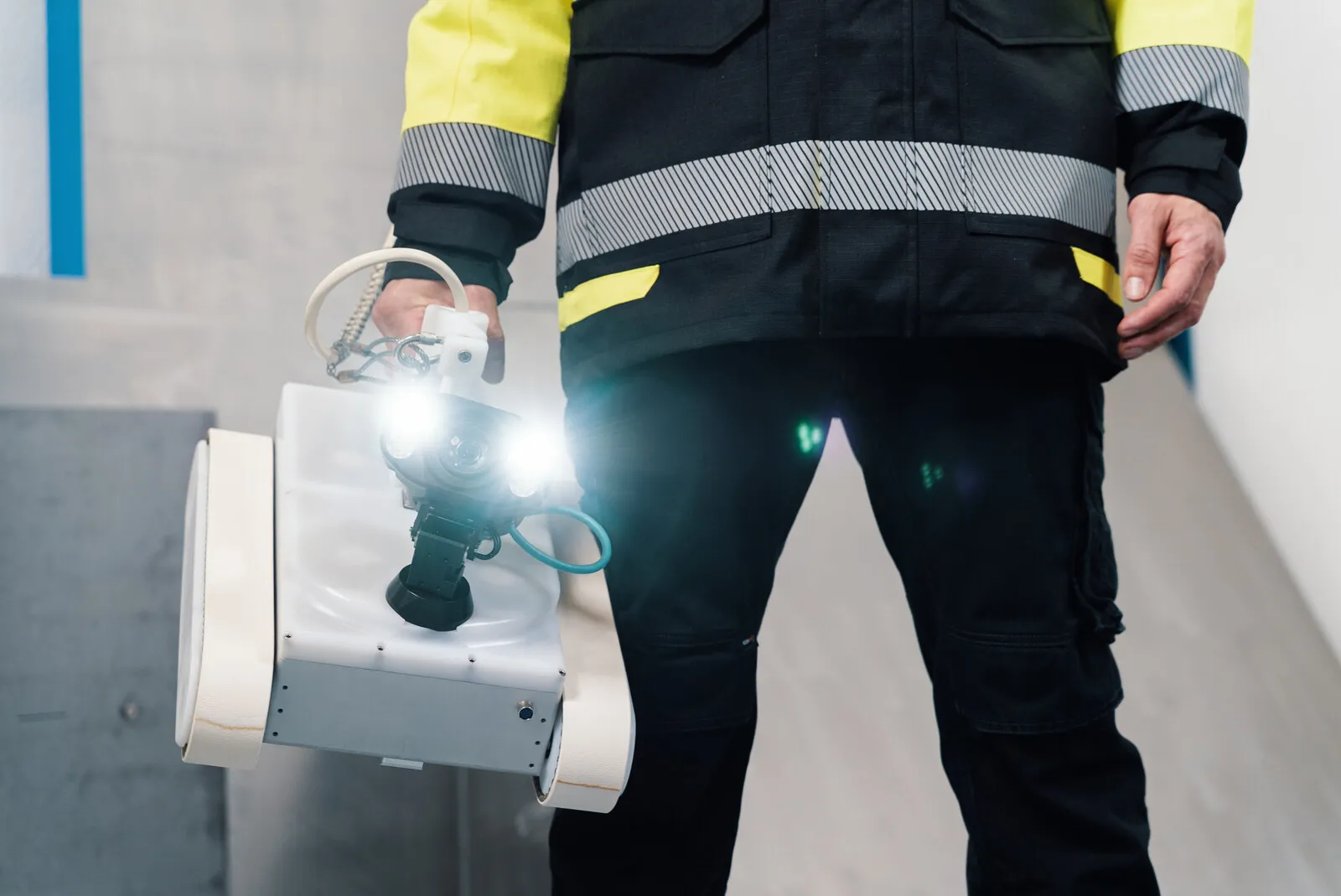 Een operator draagt de crawler met de hand naar de wand