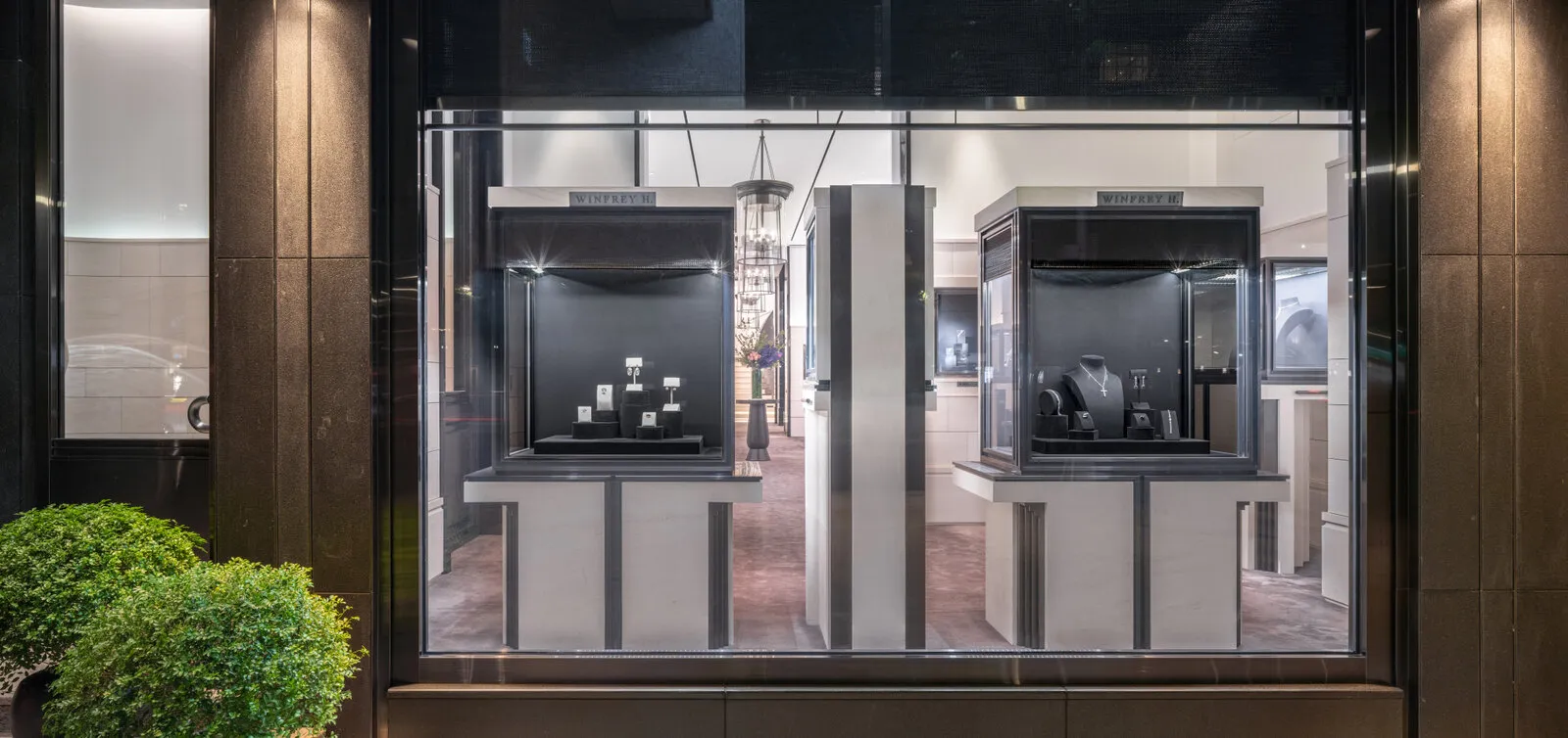 De verlichte etalage bij avond, twee vitrines met sieraden achter het glas