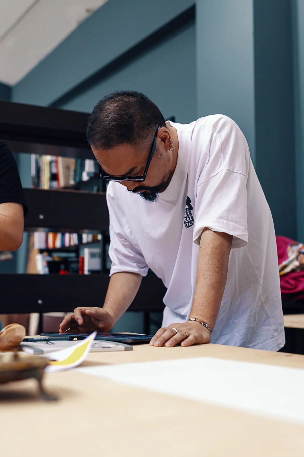 Takumi Ogata gebogen over de tafel, werkend aan een proef