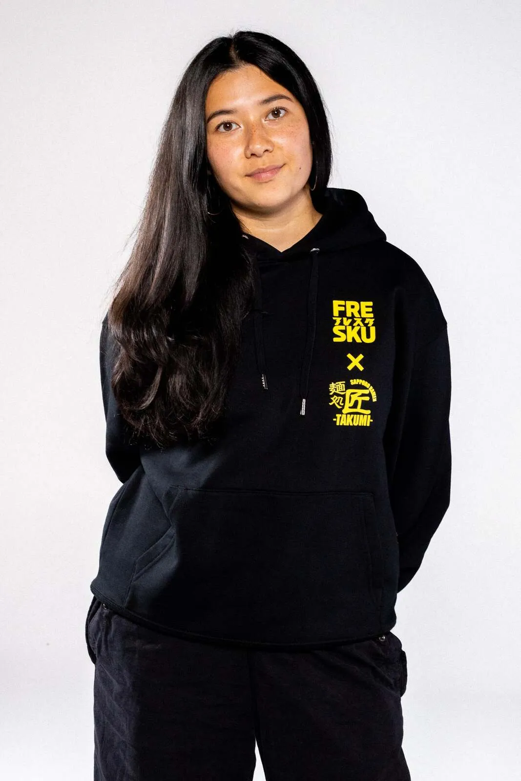 De zwarte Fresku x Takumi hoodie, met het gezichtenwerk van Ogata over de rug